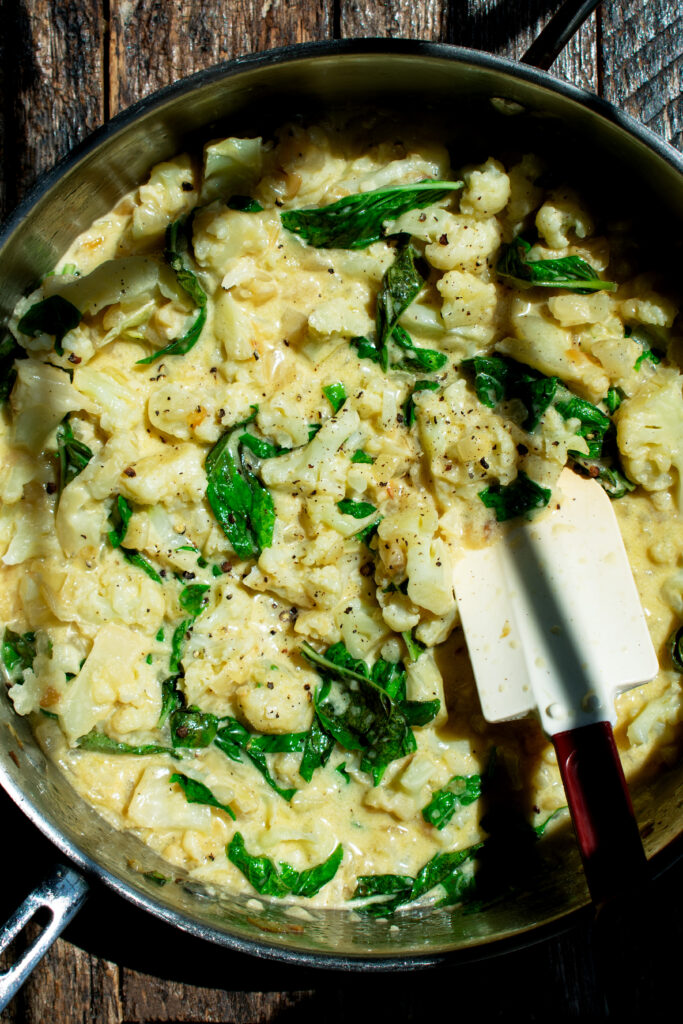cauliflower in a skillet cooking with cream and spinach