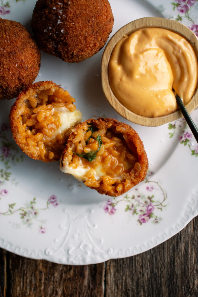 three arancini with a side of calabrian chili aioli