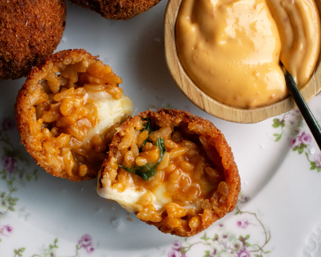 three arancini with a side of calabrian chili aioli