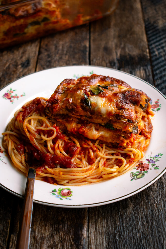 eggplant parmesan and spaghetti on a plate with tomato sauce