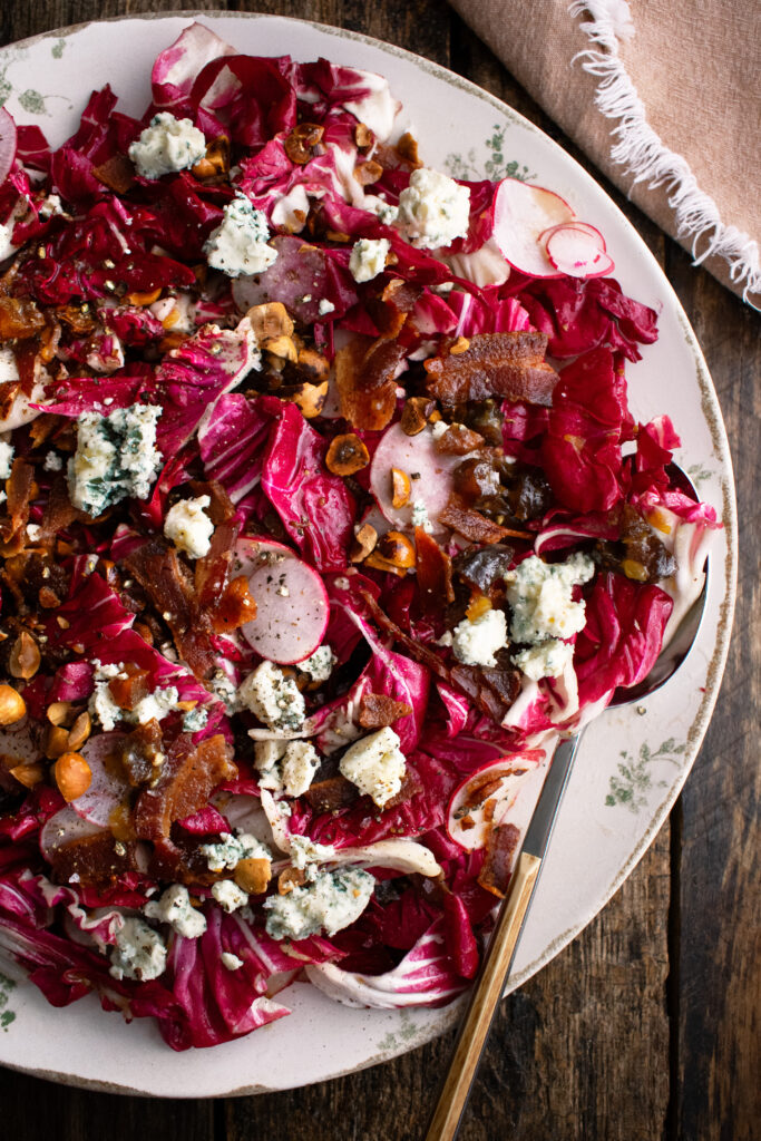 a large platter of radicchio salad with radishes, bacon, blue cheese, and hazelnuts