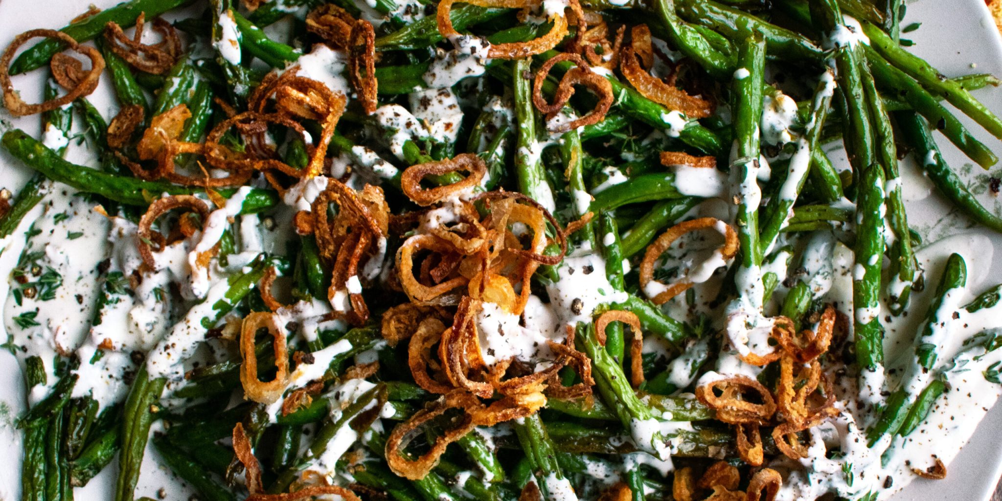 Roasted Green Beans with buttermilk dressing and crispy shallots on a plate